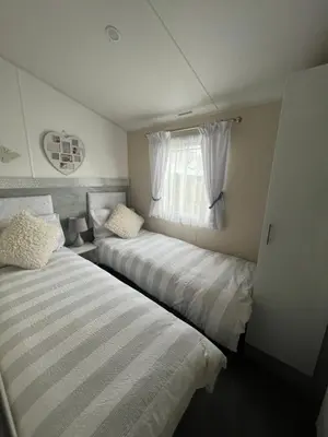 two beds in a small room with a window at The Linwood at StrathavonRentals in Girvan