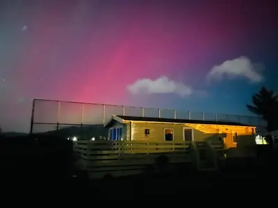 a house with a pink sky in the background at The Linwood at StrathavonRentals in Girvan