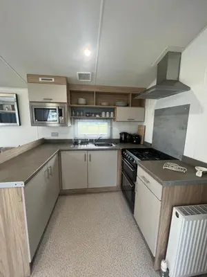 a kitchen with white cabinets and a stove top oven at The Linwood at StrathavonRentals in Girvan