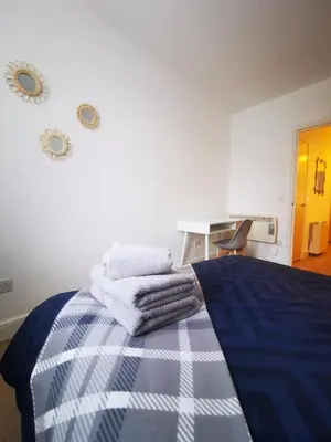 a bedroom with a bed with towels on it at Stevenson Apartment in Oban City in Oban