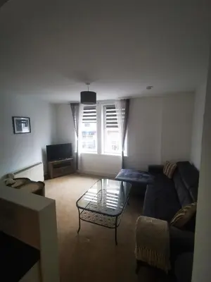 a living room with a couch and a glass table at Stevenson Apartment in Oban City in Oban