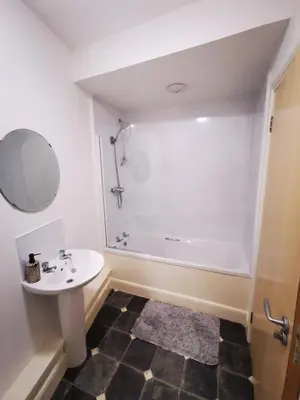 a bathroom with a sink and a bath tub at Stevenson Apartment in Oban City in Oban