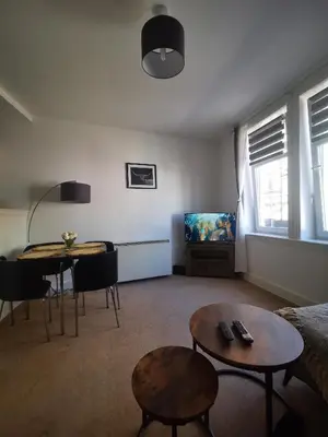 a living room with a couch and a table and a tv at Stevenson Apartment in Oban City in Oban