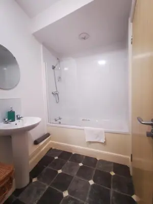 a bathroom with a tub and a sink at Stevenson Apartment in Oban City in Oban