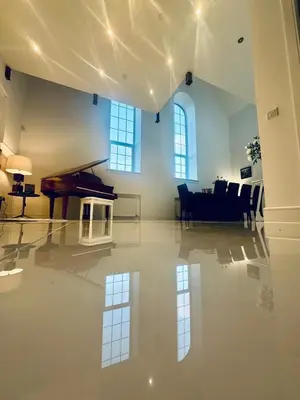 a living room with a piano and a dining room at The Bell Tower in Bonnybridge