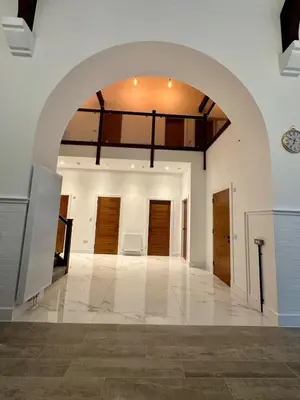 an archway in a room with wooden doors at The Bell Tower in Bonnybridge