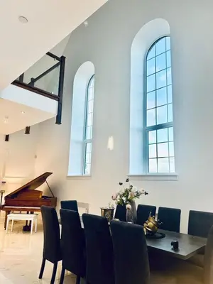a dining room with a table and chairs and a piano at The Bell Tower in Bonnybridge