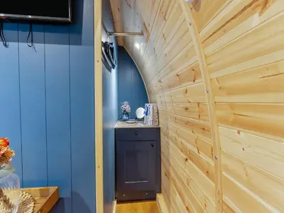 a wooden wall in a room with a black cabinet at Woodland Pod in Leadburn