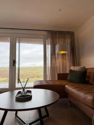 a living room with a couch and a table and a window at West Riverside Farm in Stirling