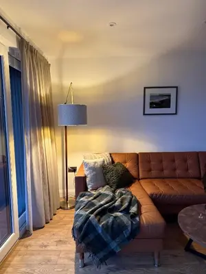 a living room with a brown couch and a table at West Riverside Farm in Stirling