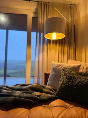 a bedroom with a bed and a lamp and a window at West Riverside Farm in Stirling