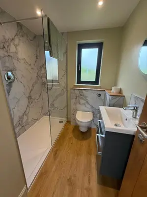 a bathroom with a shower and a toilet and a sink at Loganlea Lodge in Loanhead