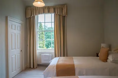 a bedroom with a bed and a large window at West Plean House in Stirling