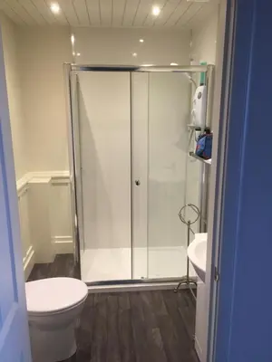 a bathroom with a shower and a toilet and a sink at The Shorehouse in Brodick