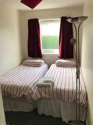 two twin beds in a room with a window at The Shorehouse in Brodick
