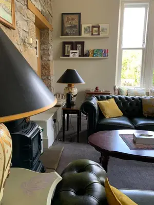 a living room with a couch and a fire place at Creity Hall Guest House in Doune