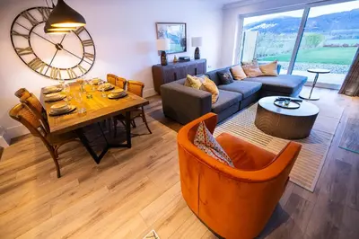 a living room with a table and a couch at Bracken Lodge in Comrie