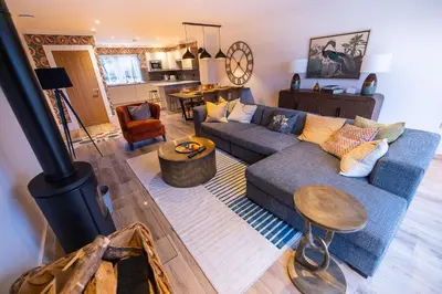 a living room with a blue couch and a stove at Bracken Lodge in Comrie