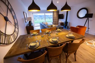a dining room with a wooden table and chairs at Bracken Lodge in Comrie