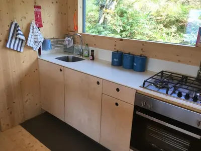a kitchen with a sink and a stove at Cala Fearnadh Off-Grid cabin, Bunessan, Mull in Bunessan