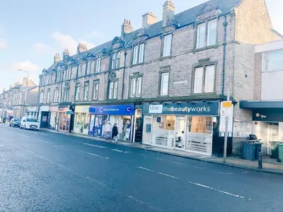 a city street with shops on the side of a building at Chic flat close to Edinburgh, Airport, & Zoo in Edinburgh