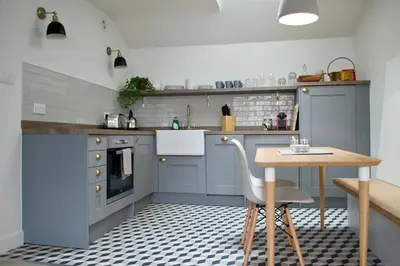 a kitchen with blue cabinets and a wooden table at The Muse in Edinburgh