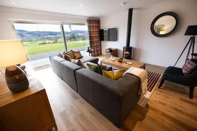 a living room with a couch and a table at Thistle Lodge in Comrie