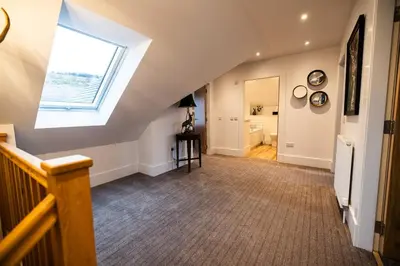 an attic hallway with a skylight and a window at Thistle Lodge in Comrie