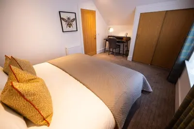 a hotel room with a bed and a desk at Thistle Lodge in Comrie