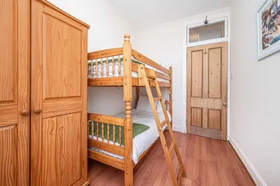 a bedroom with two bunk beds and a closet at Number Two Aberdour - Pretty Village nr Edinburgh in Aberdour