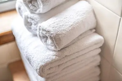a stack of white towels on a towel rack in a bathroom at Number Two Aberdour - Pretty Village nr Edinburgh in Aberdour