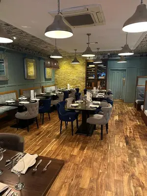 a dining room with tables and chairs in a restaurant at The Tudor Hotel in Airdrie