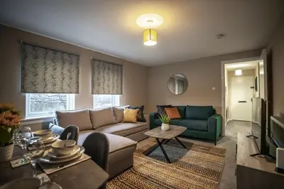 a living room with a couch and a table at Bonnie Apartment in Coatbridge