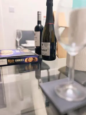 a bottle of wine sitting next to a wine glass at King Apartment in Falkirk