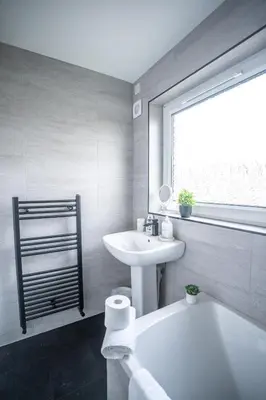 a white bathroom with a sink and a tub and a toilet at Bank House in Livingston