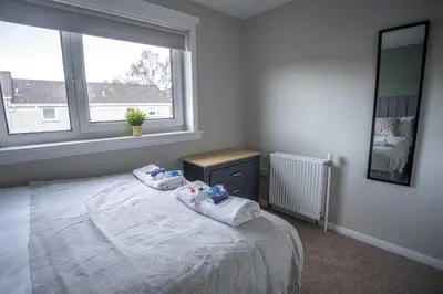 a bedroom with a bed with two babies on it at Bank House in Livingston