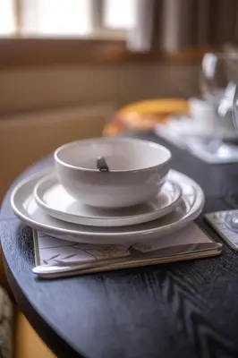 a white bowl on a plate on a table at Muirhead House in Motherwell