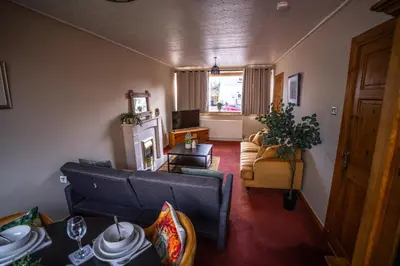 a living room with a couch and a chair at Muirhead House in Motherwell