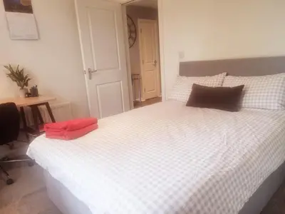 a bedroom with a large white bed with red pillows at Modern Two Bed Glasgow Apartment with Free Parking in Glasgow