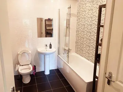 a bathroom with a toilet and a sink and a tub at Modern Two Bed Glasgow Apartment with Free Parking in Glasgow