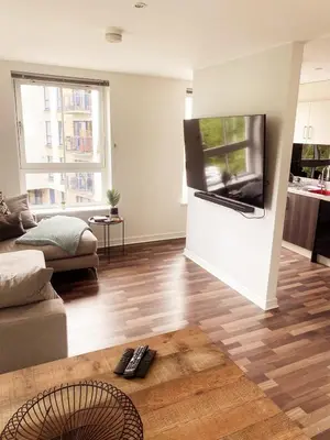 a living room with a flat screen tv on a wall at Modern Two Bed Glasgow Apartment with Free Parking in Glasgow