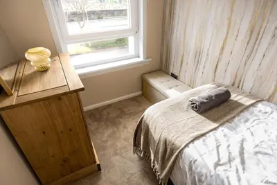 a small bedroom with a bed and a window at Spacious 3 Bed Home in Glasgow City With Free Parking in Glasgow