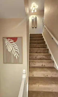a staircase in a house with a painting on the wall at Spacious 3 Bed Home in Glasgow City With Free Parking in Glasgow