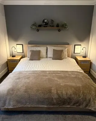 a bedroom with a large bed with two night stands at Gellyburn Cottage in Kinross