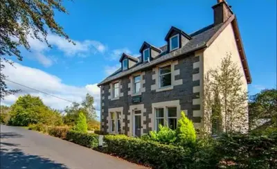 a large stone house with a roof at Snug Loft Room, Room 5, Beautiful Connel near Oban in Connel