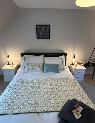 a bedroom with a large bed with two night stands at Snug Loft Room, Room 5, Beautiful Connel near Oban in Connel