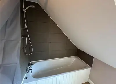 a bath tub in a bathroom with a shower at Snug Loft Room, Room 5, Beautiful Connel near Oban in Connel