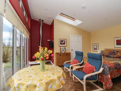 a bedroom with a table and chairs and a bed at Tirlaggan Studio in Oban