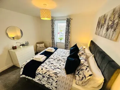 a bedroom with a bed and a mirror at Kilmartin Court Apartments - No3 By The Sea & No2 With A View - free parking in Oban