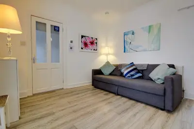 a living room with a couch in a room at Apartment Caerlaverock Road in Prestwick